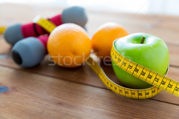 close up of dumbbell, fruits and measuring tape Stock photo © dolgachov