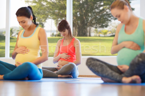 happy pregnant women exercising yoga in gym Stock photo © dolgachov