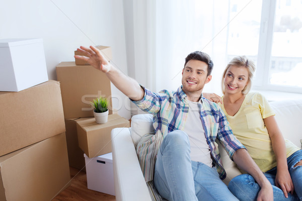 couple with boxes moving to new home and dreaming Stock photo © dolgachov