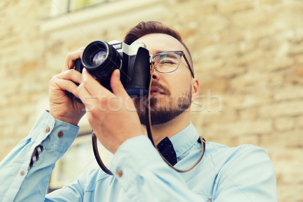 young hipster man with film camera in city Stock photo © dolgachov