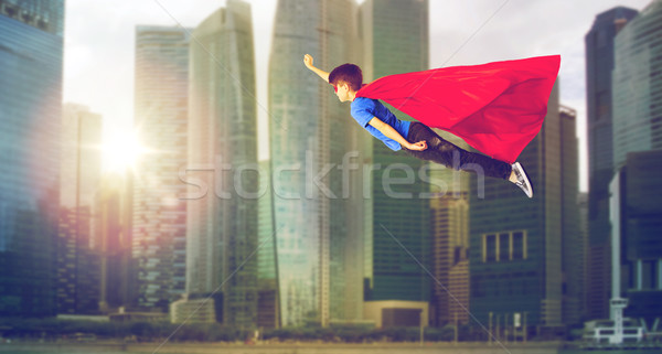 boy in superhero cape and mask flying over city Stock photo © dolgachov