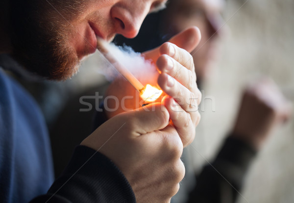 Stock photo: close up of young people smoking cigarette