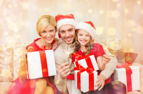 smiling family holding gift boxes and sparkles Stock photo © dolgachov