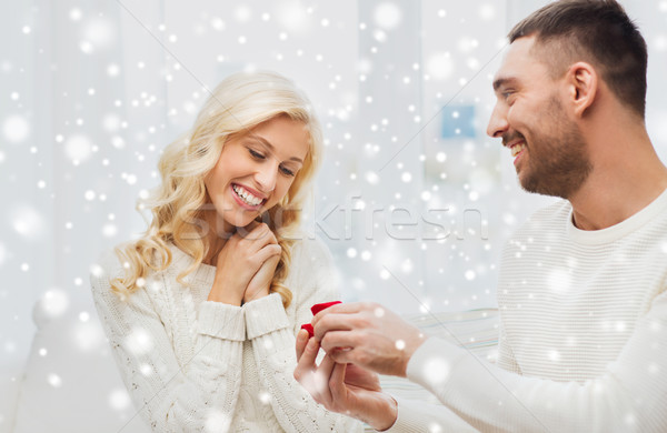 happy man giving engagement ring to woman at home Stock photo © dolgachov