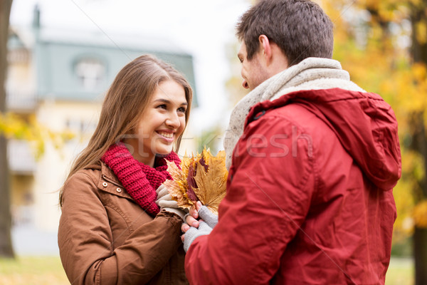 happy couple with maple leaves in autumn park Stock photo © dolgachov