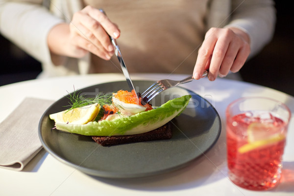 woman eating caviar toast skagen at restaurant Stock photo © dolgachov