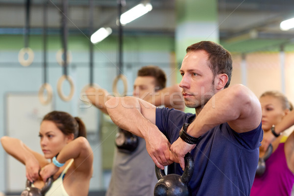 group of people with kettlebells exercising in gym Stock photo © dolgachov