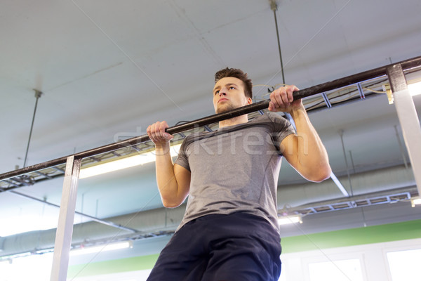 man exercising on bar and doing pull-ups in gym Stock photo © dolgachov