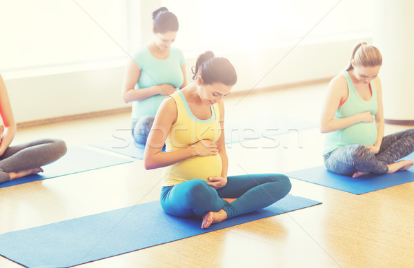 happy pregnant women exercising yoga in gym Stock photo © dolgachov