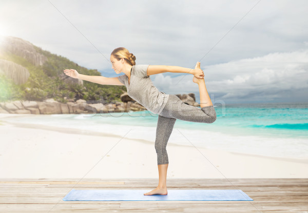 woman in yoga lord of the dance pose on beach Stock photo © dolgachov