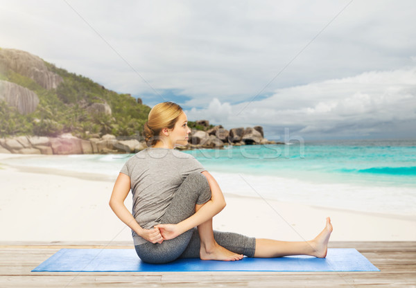 woman doing yoga in twist pose on beach Stock photo © dolgachov