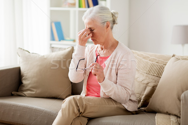 senior woman with glasses having headache at home Stock photo © dolgachov