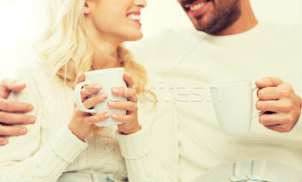 close up of happy couple with tea cups at home Stock photo © dolgachov