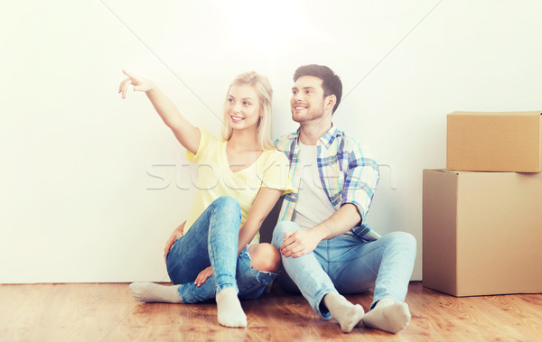 couple with boxes moving to new home and dreaming Stock photo © dolgachov