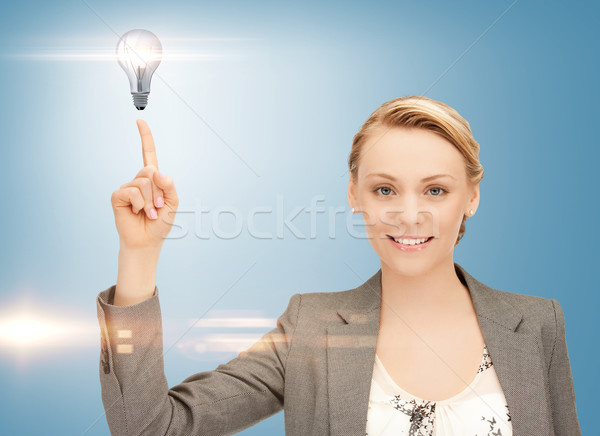 Kobieta wskazując palec żarówka piękna kobieta świetle Zdjęcia stock © dolgachov