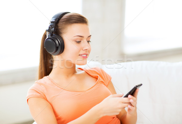 woman with headphones and smartphone at home Stock photo © dolgachov