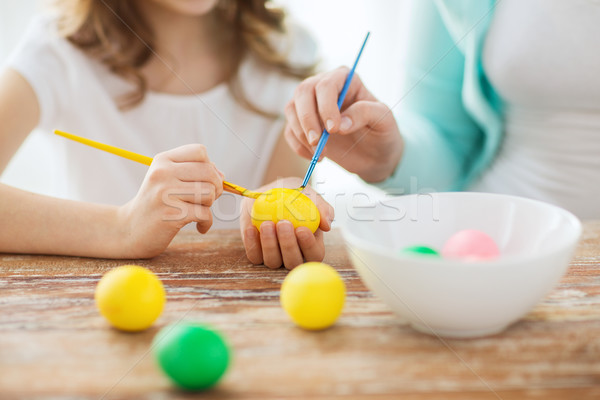 close up of little girl and mother coloring eggs Stock photo © dolgachov