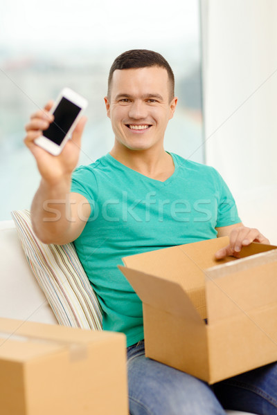 opening cardboard box and taking out smartphone Stock photo © dolgachov