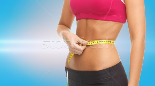 close up trained belly with measuring tape Stock photo © dolgachov