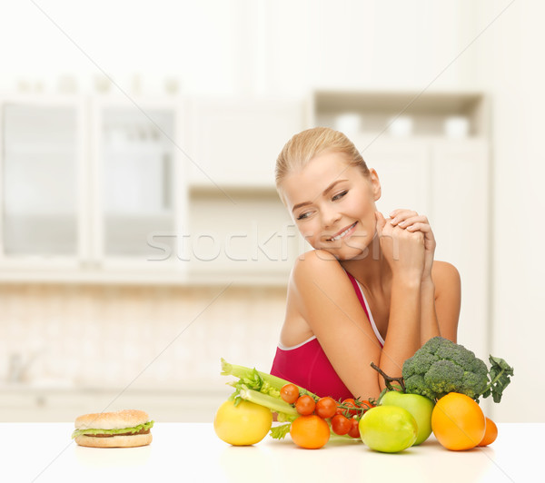 Stock photo: doubting woman with fruits and hamburger