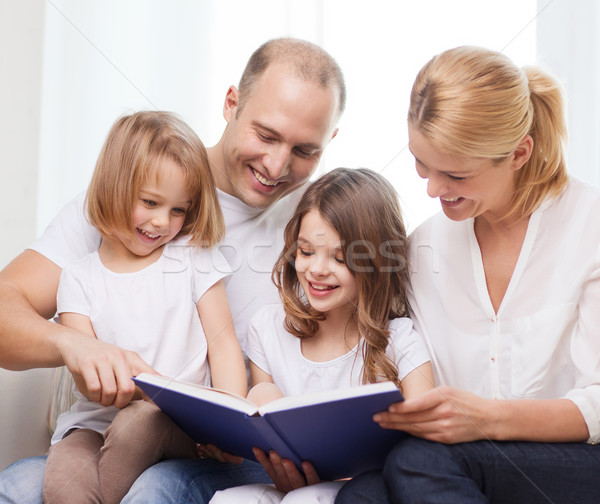smiling family and two little girls with book Stock photo © dolgachov