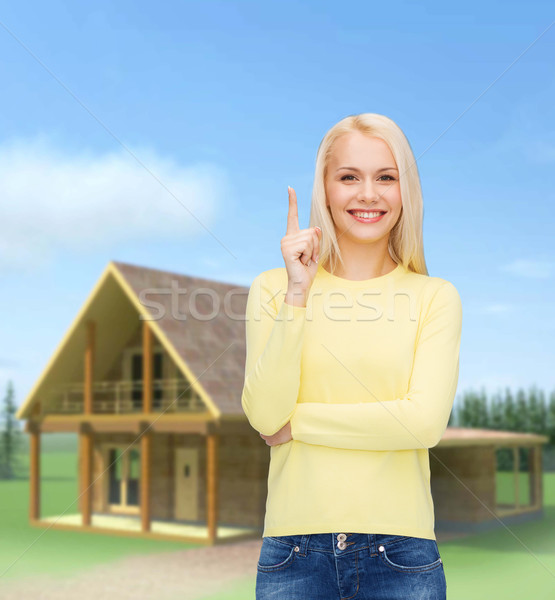 Uśmiechnięta kobieta wskazując palec w górę reklama atrakcyjny Zdjęcia stock © dolgachov