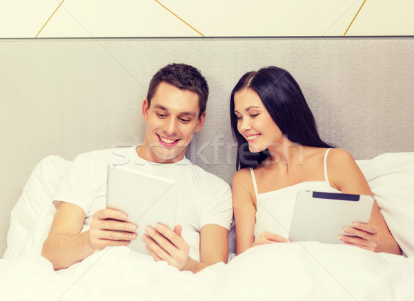 smiling couple in bed with tablet pc computers Stock photo © dolgachov