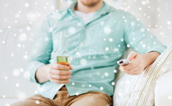 man with beer and remote control at home Stock photo © dolgachov