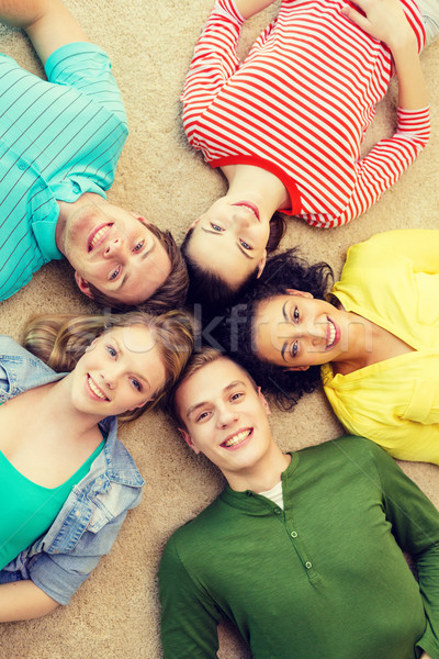 Group Of Smiling People Lying Down On Floor Stock Photo C Syda