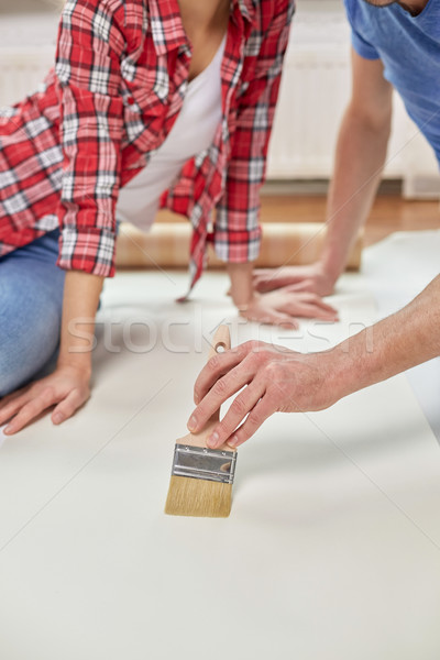close up of couple smearing wallpaper with glue Stock photo © dolgachov