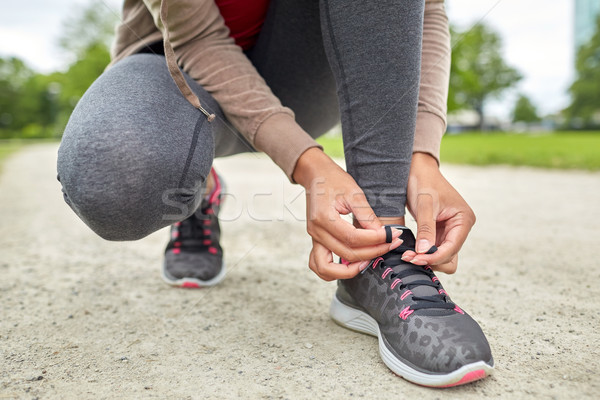 Stock photo: close up of woman tying shoelaces outdoors