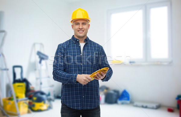 smiling man in helmet with gloves over room Stock photo © dolgachov