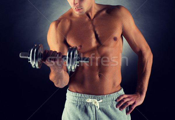 close up of young man with dumbbell Stock photo © dolgachov