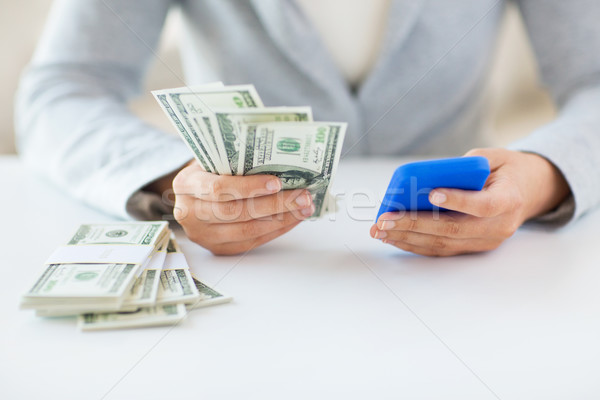 close up of woman hands with smartphone and money Stock photo © dolgachov