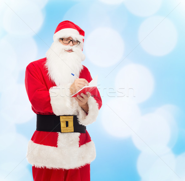 man in costume of santa claus with notepad Stock photo © dolgachov