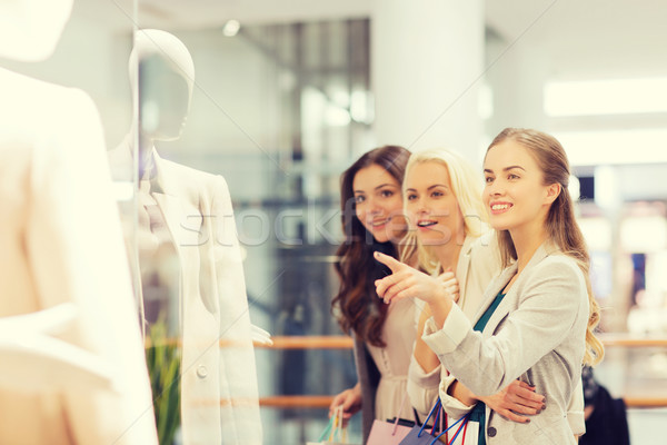 Stock photo: happy young women with shopping bags in mall