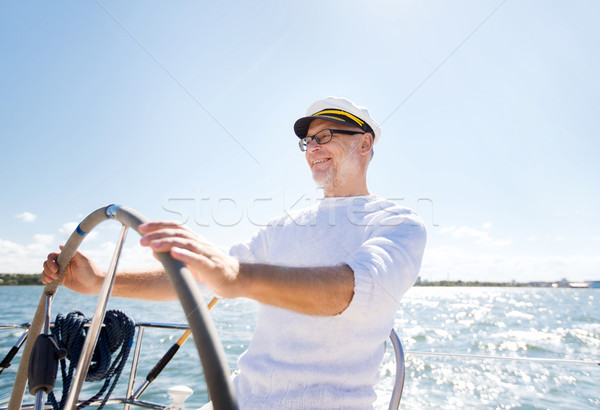 senior man at helm on boat or yacht sailing in sea Stock photo © dolgachov