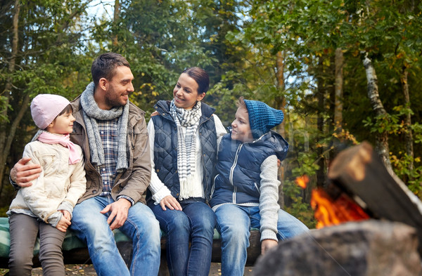 happy family sitting on bench at camp fire Stock photo © dolgachov