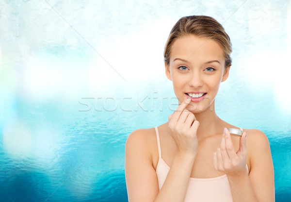 Souriant jeune femme lèvre baume lèvres Photo stock © dolgachov