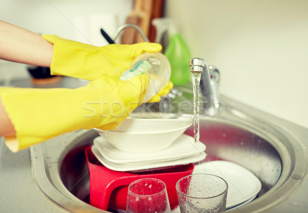 Stock photo: close up of woman hands washing dishes in kitchen