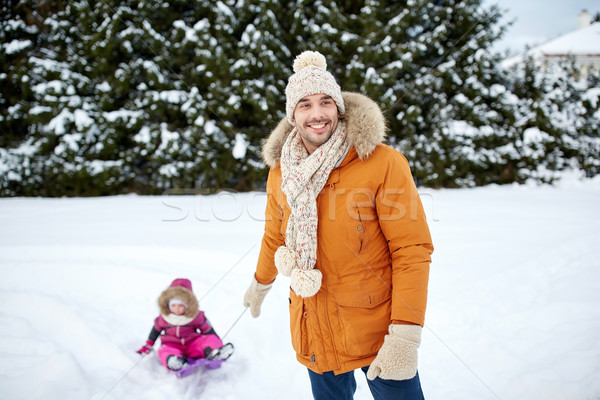happy man carrying little kid on sled in winter Stock photo © dolgachov