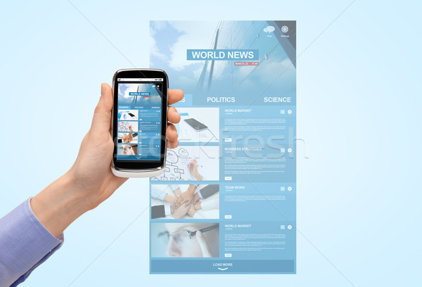 Stock photo: close up of hand with news web page on smartphone