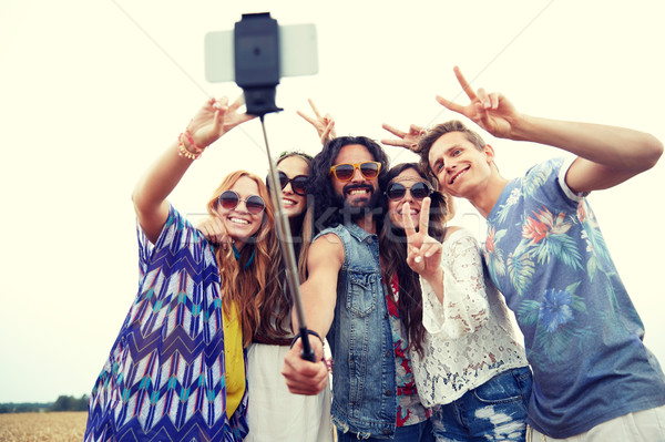 hippie friends with smartphone on selfie stick Stock photo © dolgachov