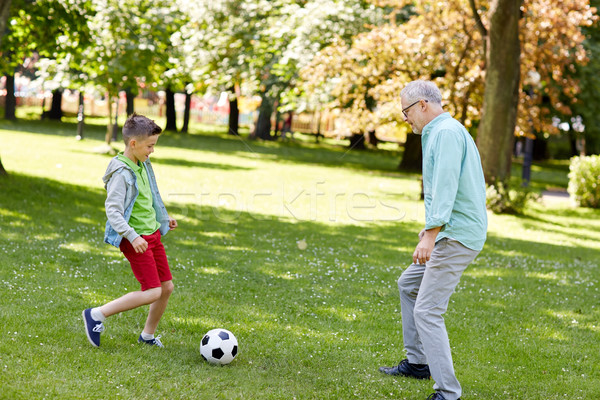 old man and boy playing football at summer park Stock photo © dolgachov