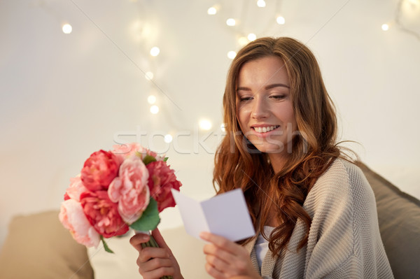 happy woman with flowers and greeting card at home Stock photo © dolgachov