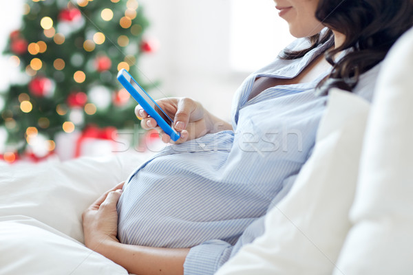 Donna incinta smartphone letto gravidanza vacanze Foto d'archivio © dolgachov