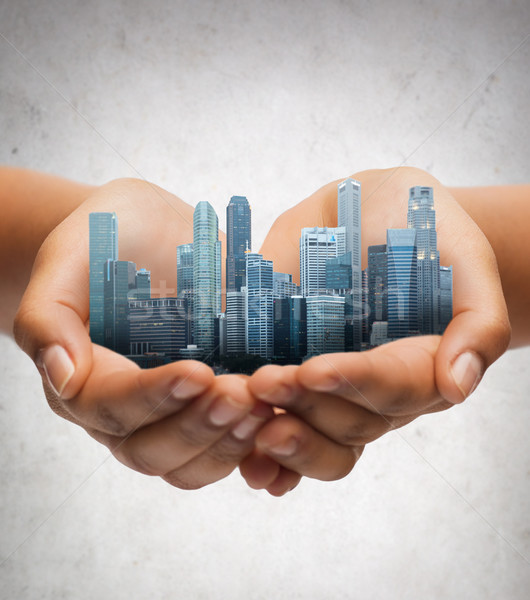 hands holding city over gray concrete background Stock photo © dolgachov
