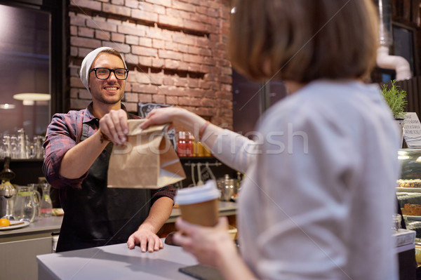 woman taking paper bag from seller at cafe Stock photo © dolgachov