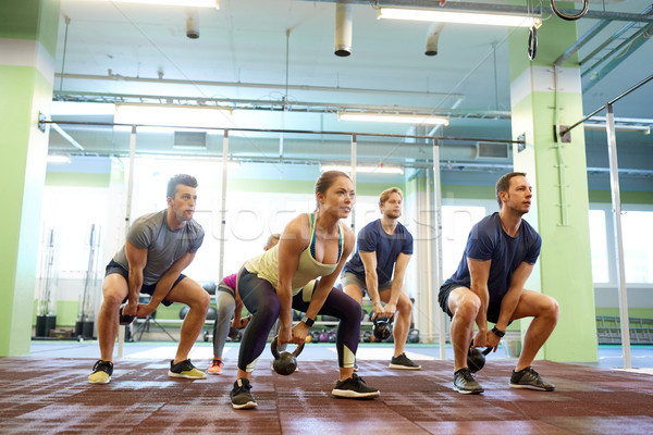 group of people with kettlebells exercising in gym Stock photo © dolgachov