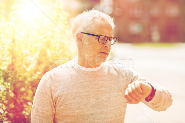 senior man checking time on his wristwatch Stock photo © dolgachov
